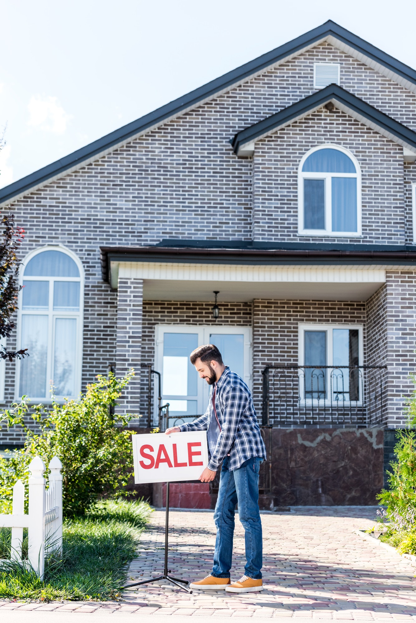 young man with sale board selling his new house